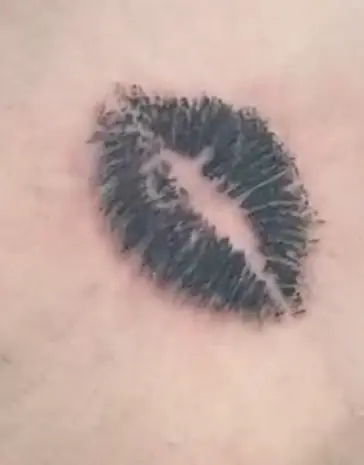 Black and gray lip-print tattoo