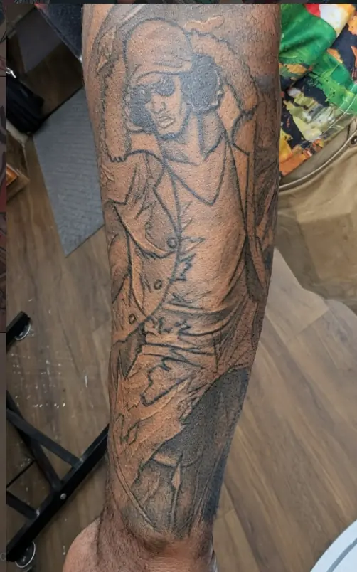Black and gray illustrative full-arm tattoo