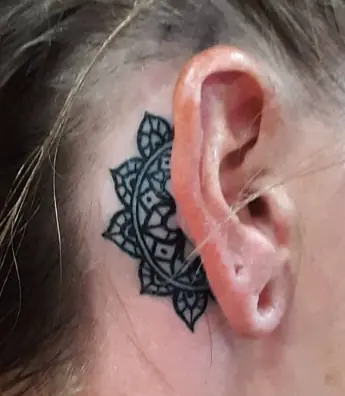Black ornamental tattoo wrapping behind the ear