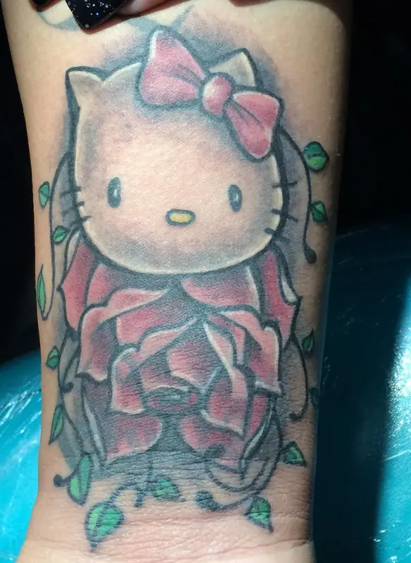 Color Hello Kitty tattoo framed by a rose